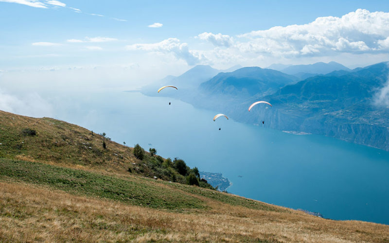 group of paragliders over lake garda